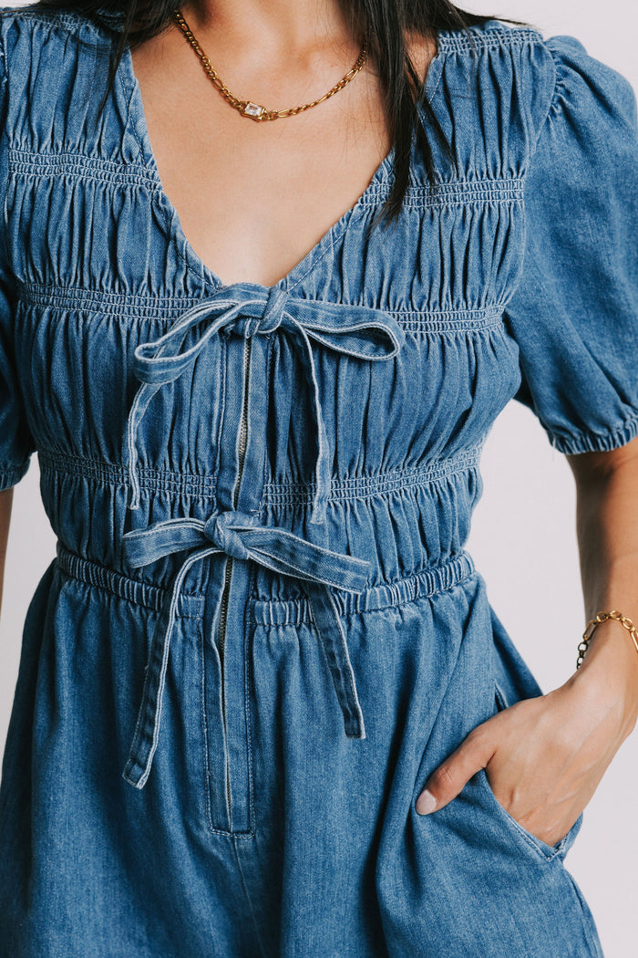 blue denim v neck romper with bows and gathered detail bodice