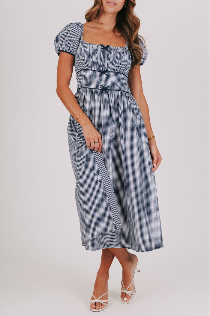 blue gingham dress with puff sleeves and bow details
