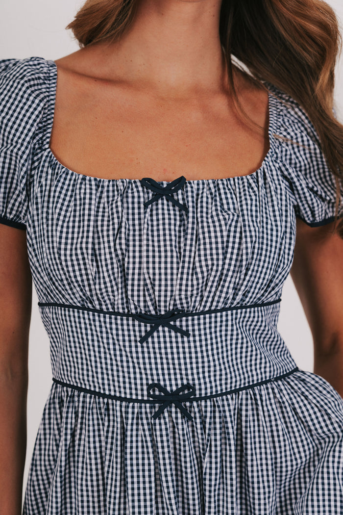 blue gingham dress with puff sleeves and bow details bodice