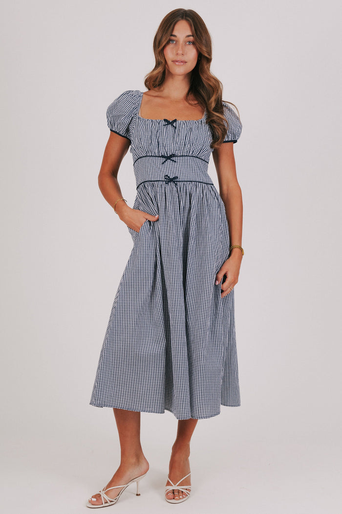 blue gingham dress with puff sleeves and bow details front