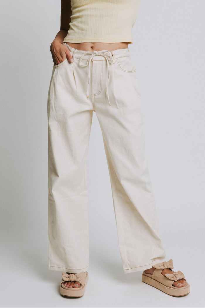 ivory jeans with tie at the waist and contrast stitching